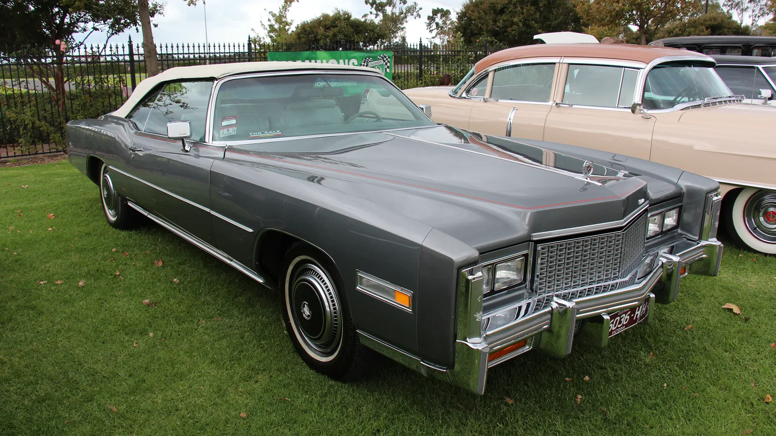 Grey 1976 Cadillac Eldorado convertible with the top up, front three-quarter view, at a car show