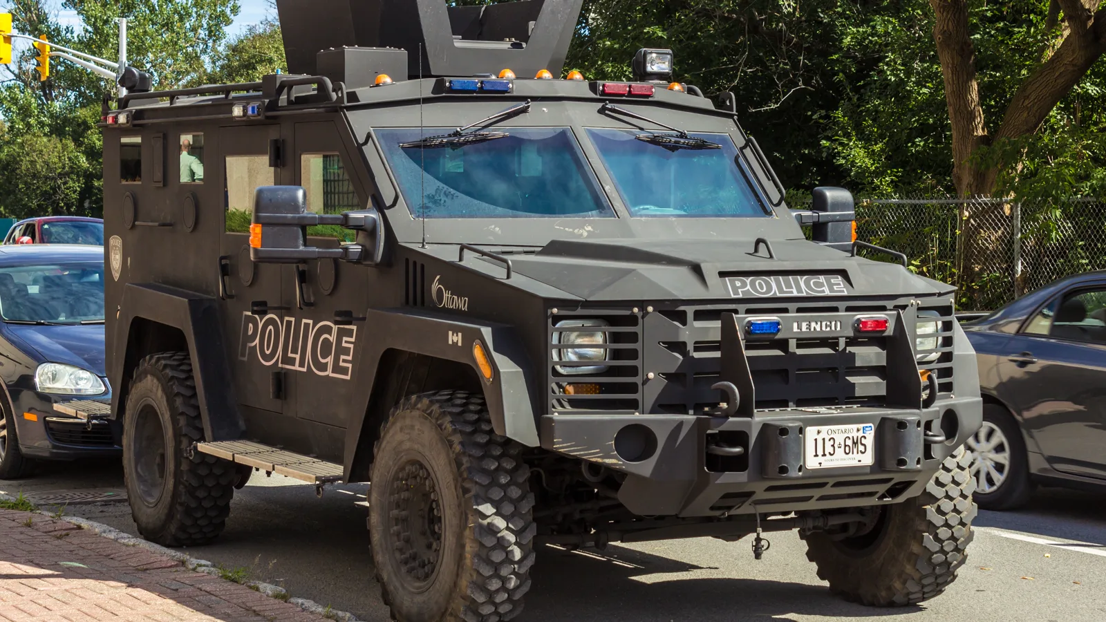 Black Lenco BearCat armored police truck, front three-quarter view, parked on a street