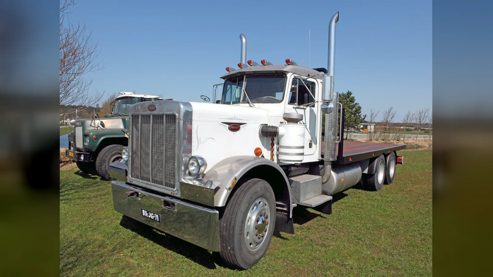 White 1979 Peterbilt 359 flatbed truck, front three-quarter view, at a truck show