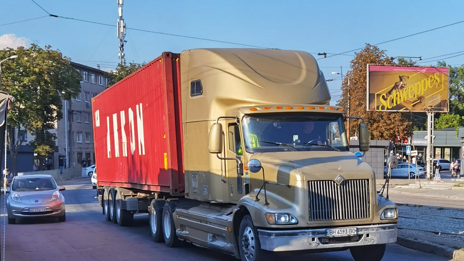 Gold International 9200 tractor hauling a red container, front three-quarter view, on a city street